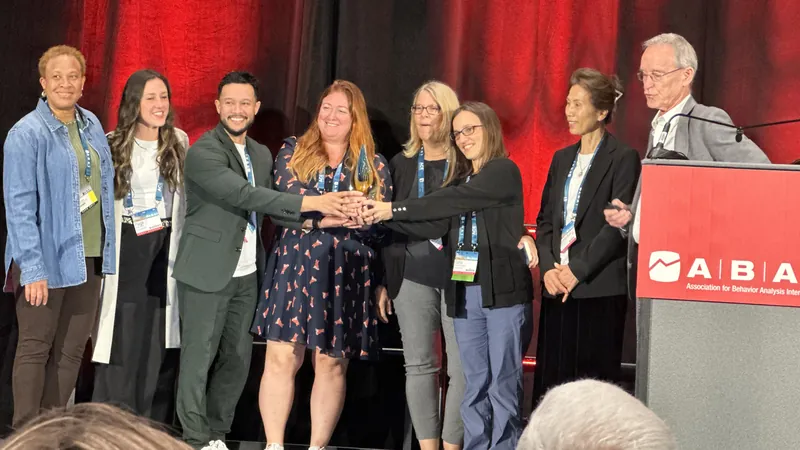 USF ABA faculty on stage at the ABAI convention, holding the SABA award together.