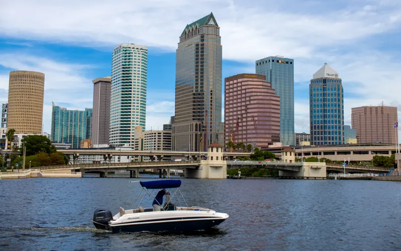 Downtown Tampa skyline across the water on a sunny day, with a boat crossing the bay.